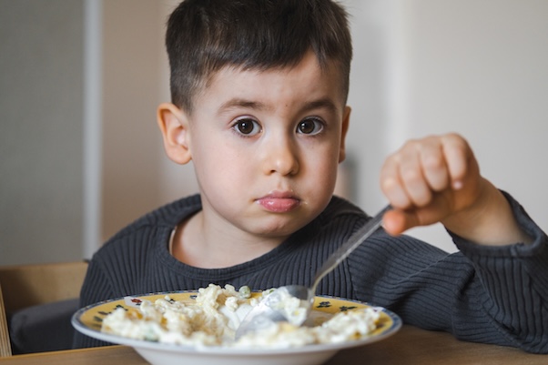 A rossz evő gyermek csak turkálja az ételt A rossz evő gyermek csak turkálja az ételt
